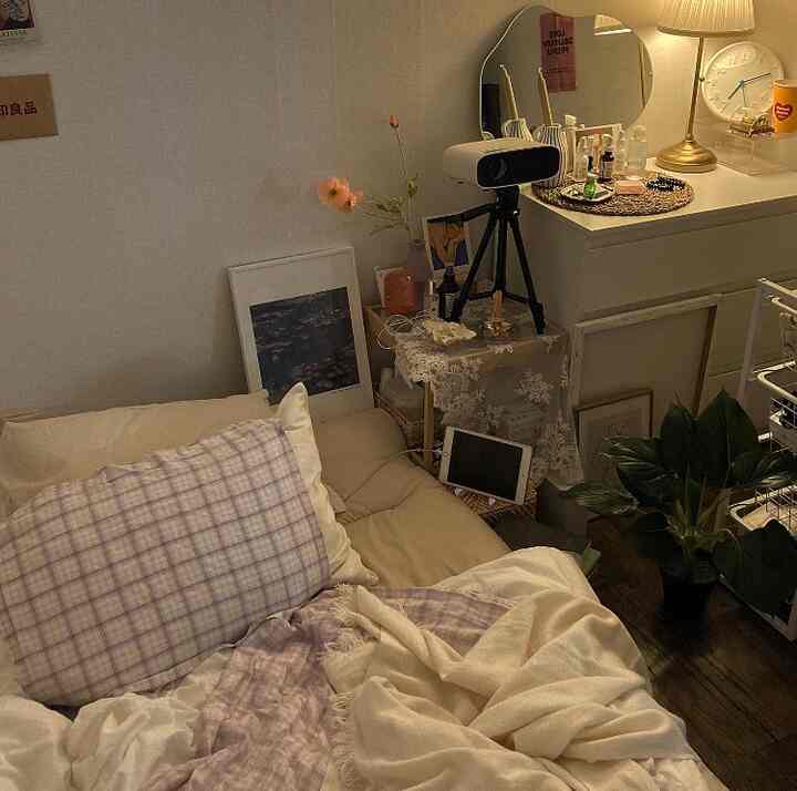 ナチュラルな色調のコンパクトな寝室、ベージュの寝具と暖かな照明が調和した落ち着いた空間