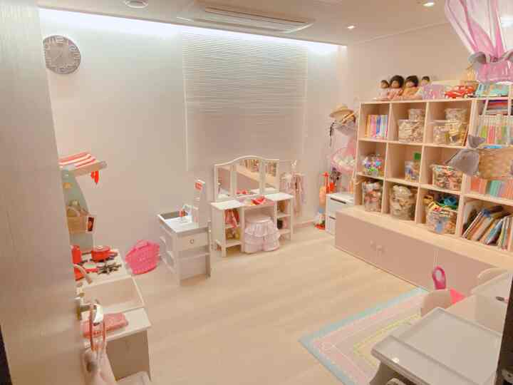 Bright natural-toned kids' room featuring beige toy storage and a small vanity neatly arranged