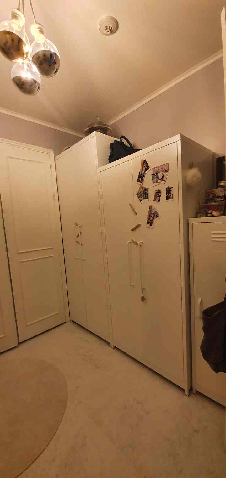 White-toned small room featuring built-in closets and wardrobes arranged neatly for storage