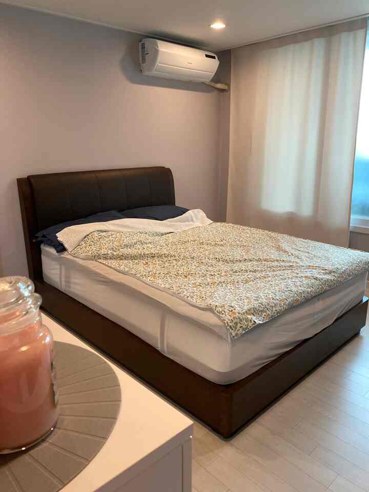 White and brown toned bedroom featuring a large bed and blackout curtains with a clean, simple atmosphere