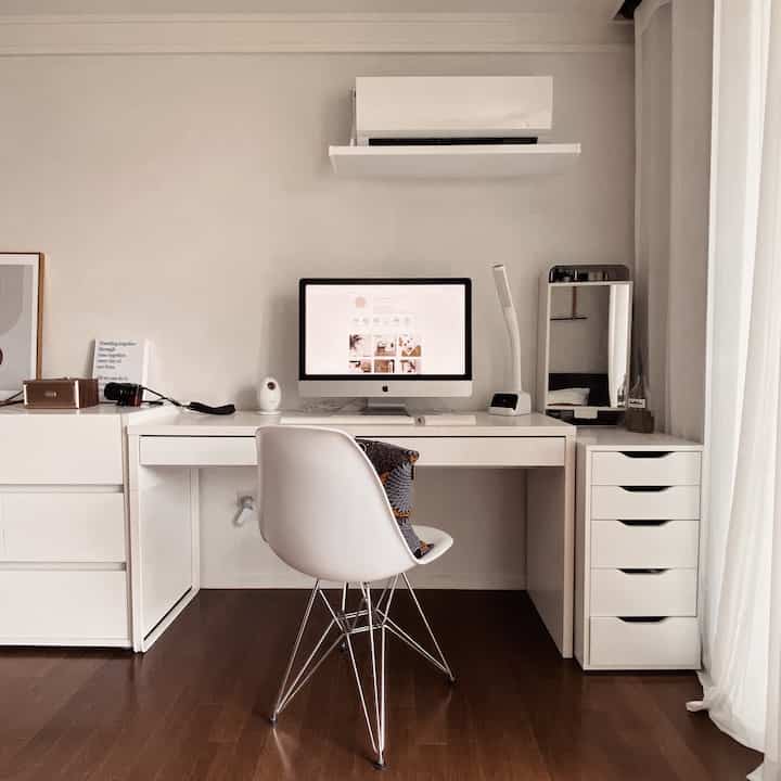 White-toned study featuring desk, drawers, and monitor arranged in a clean, simple work environment