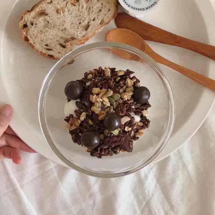 Cozy home cafe space with natural cafe-style plate and wooden cutlery on white bedding