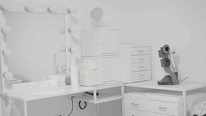 White vanity and drawer unit in a simple, clean powder room setting with minimalist style