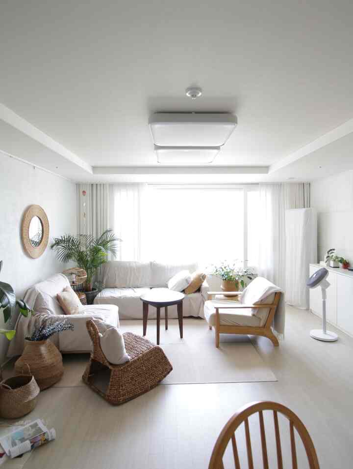 Bright white and natural tone living room featuring white sofas, wooden armchair, and natural decor creating a cozy atmosphere