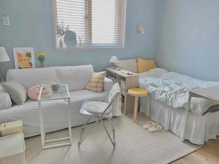 White and wood tone 10-tatami bedroom featuring sofa, nightstand, and small stool in a natural modern style space