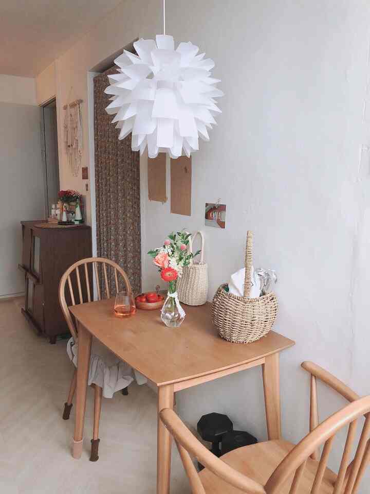 White walls with natural wood-toned dining table and chairs in a vintage-style two-person kitchen space