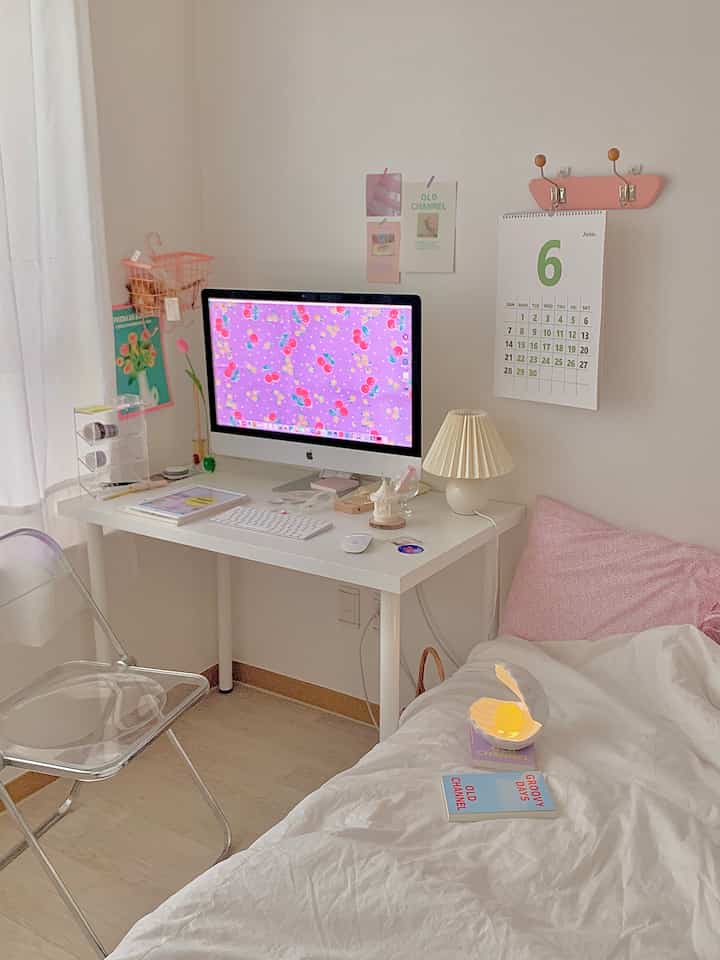 Bright white-toned bedroom and home office featuring pink accents with a charming, kitschy interior vibe