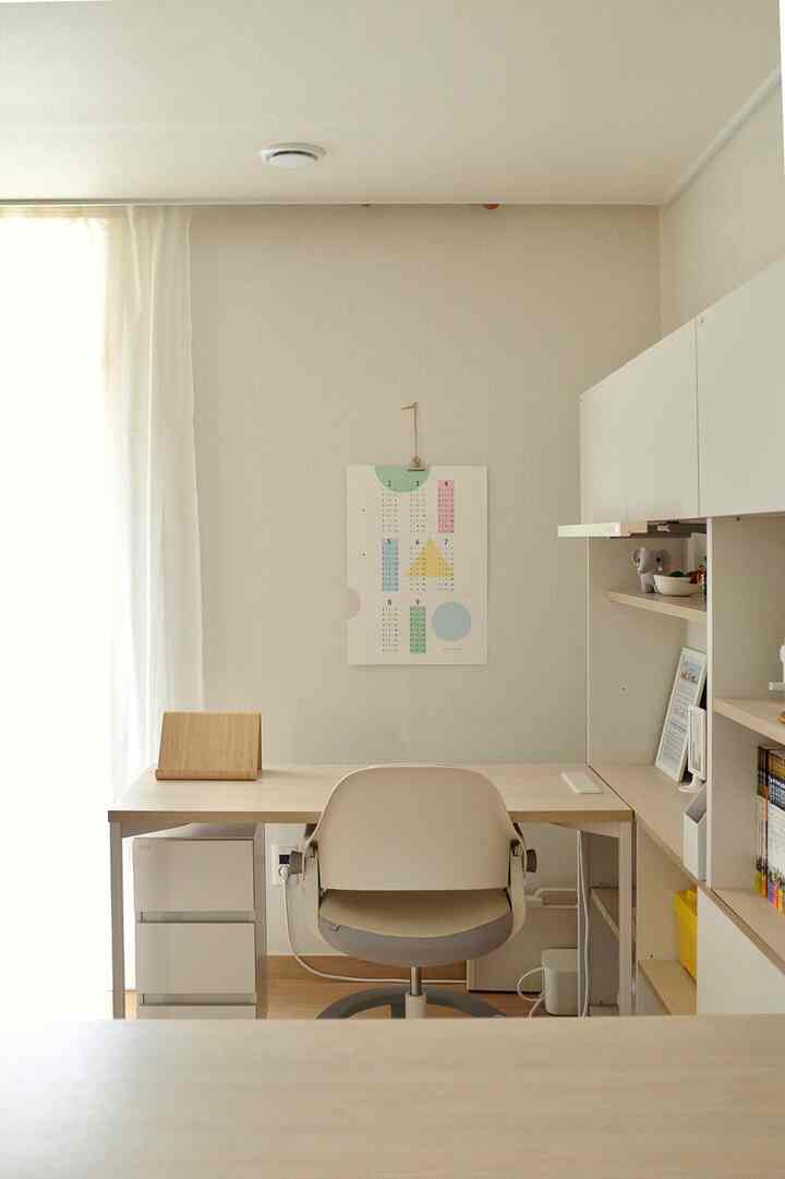 White and wood tone kids' study room featuring a simple desk and chair with a cozy atmosphere
