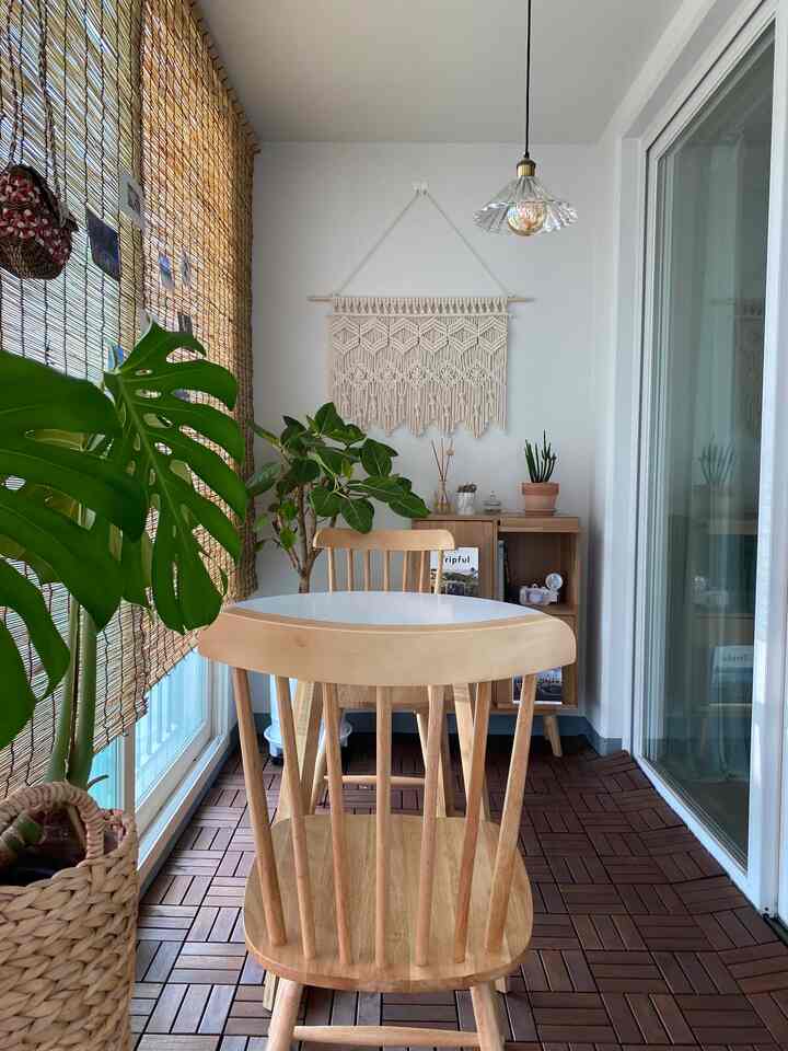 Natural-toned veranda space featuring round table and wooden dining chairs, creating a cozy home cafe atmosphere