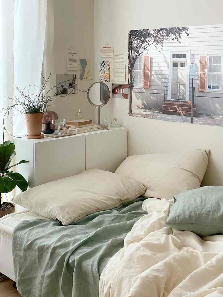 Natural color and white-toned bedroom featuring pillows and linen bedding creating a clean and cozy atmosphere