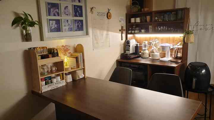 Warm wood-toned kitchen and storage dining table area featuring cozy lighting and organized cabinetry, creating practical ambiance