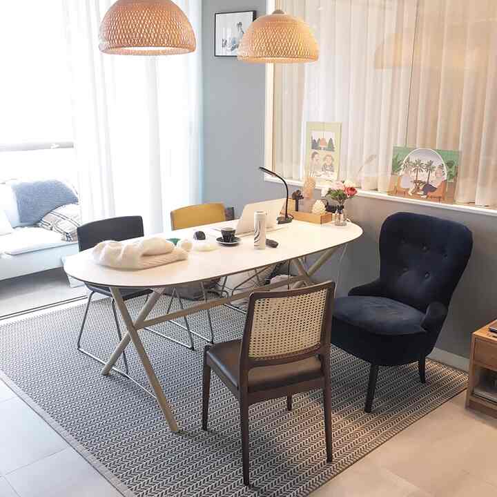Soft white and natural materials in a dining room featuring rattan chairs and pendant lights, creating a summer vibe.