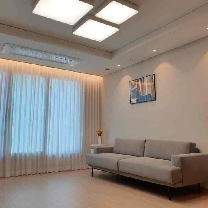 A living room with white and gray natural tones, featuring a simple sofa and side table in a sophisticated space