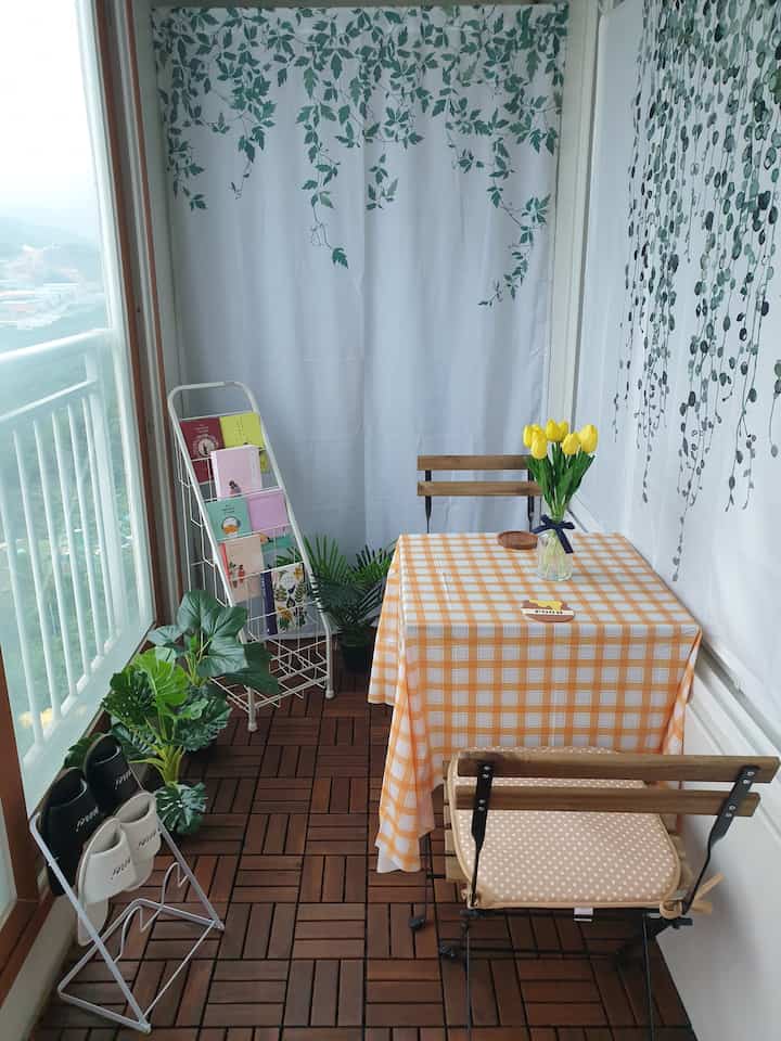 Wood tone veranda home cafe featuring yellow flowers and checkered tablecloth