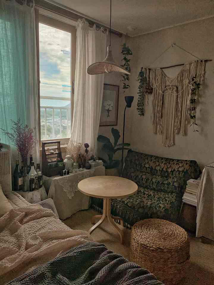 A beige and natural tone studio living room featuring macrame wall hanging and natural decor elements with a cozy atmosphere