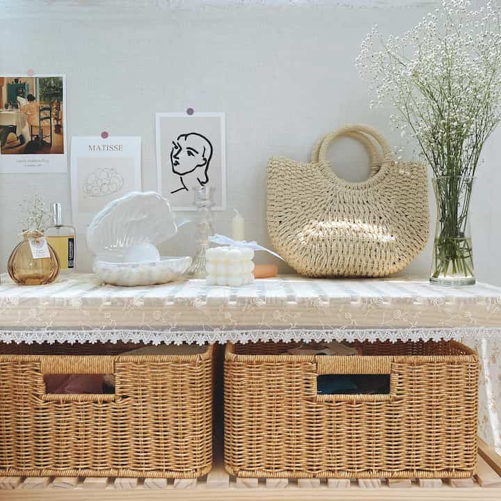 Beige and natural tone veranda featuring a shelf with objects and posters in a simple interior design