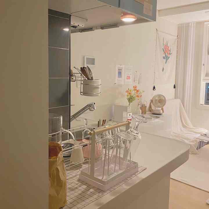 Soft white-toned kitchen space featuring corner storage cabinet with LED sensor light in a simple interior