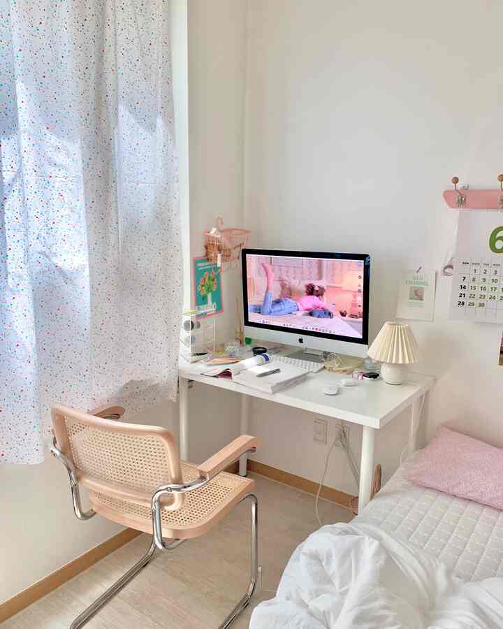 A simple single-person study room in white and rattan tones featuring a desk and bed in harmony