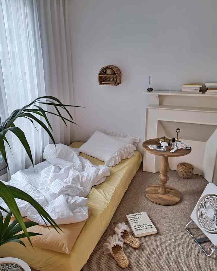 Natural color bedroom featuring rattan baskets and a round wooden table with cozy, neat atmosphere