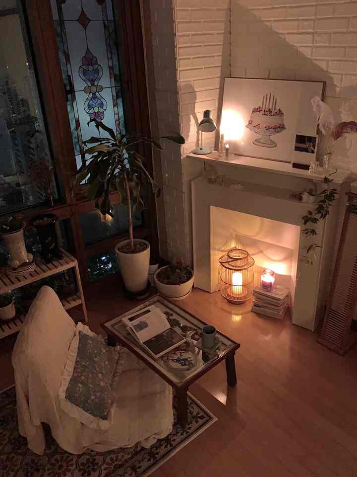 Warm wood tones and white walls in a living room featuring a fireplace console with candles creating a cozy atmosphere