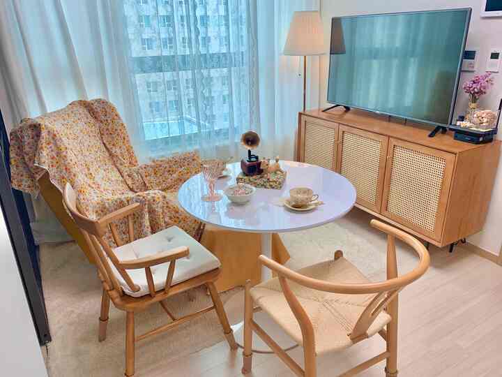 ナチュラルな雰囲気の小さな二人暮らしリビング、木製サイドボードと黄色のフローラルチェア、フロアランプ配置