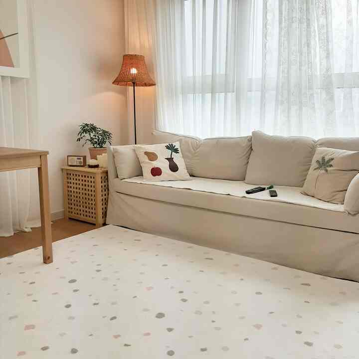 Natural modern living room with white and wood tones, cozy beige sofa and patterned rug creating a warm atmosphere