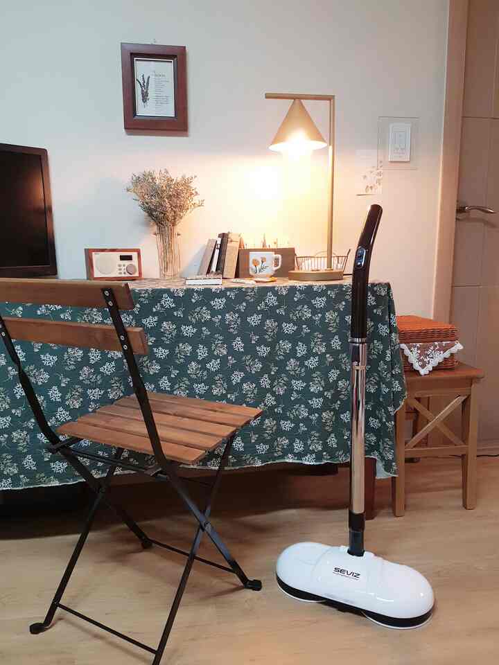 Natural wood tone and black-accented space opposite kitchen featuring table and floor lamp creating cozy atmosphere