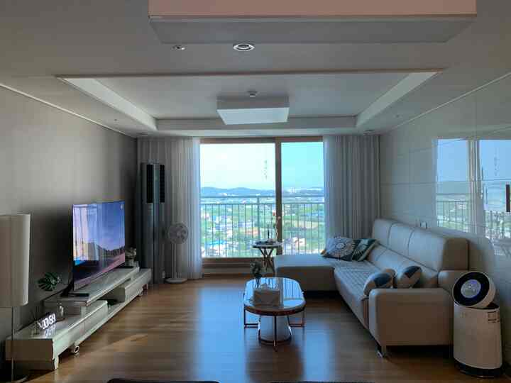 Ivory and wood tone living room featuring marble table and sofa in a simple modern setting