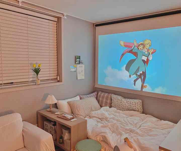 Natural modern bedroom in white and beige tones featuring a projector screen, wood blinds, and cozy bedding