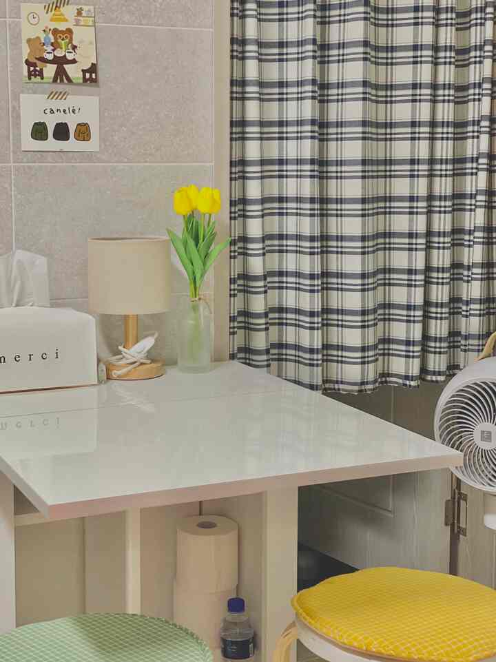 Cozy space with white and navy check curtains featuring a folding table and stools arranged neatly indoors