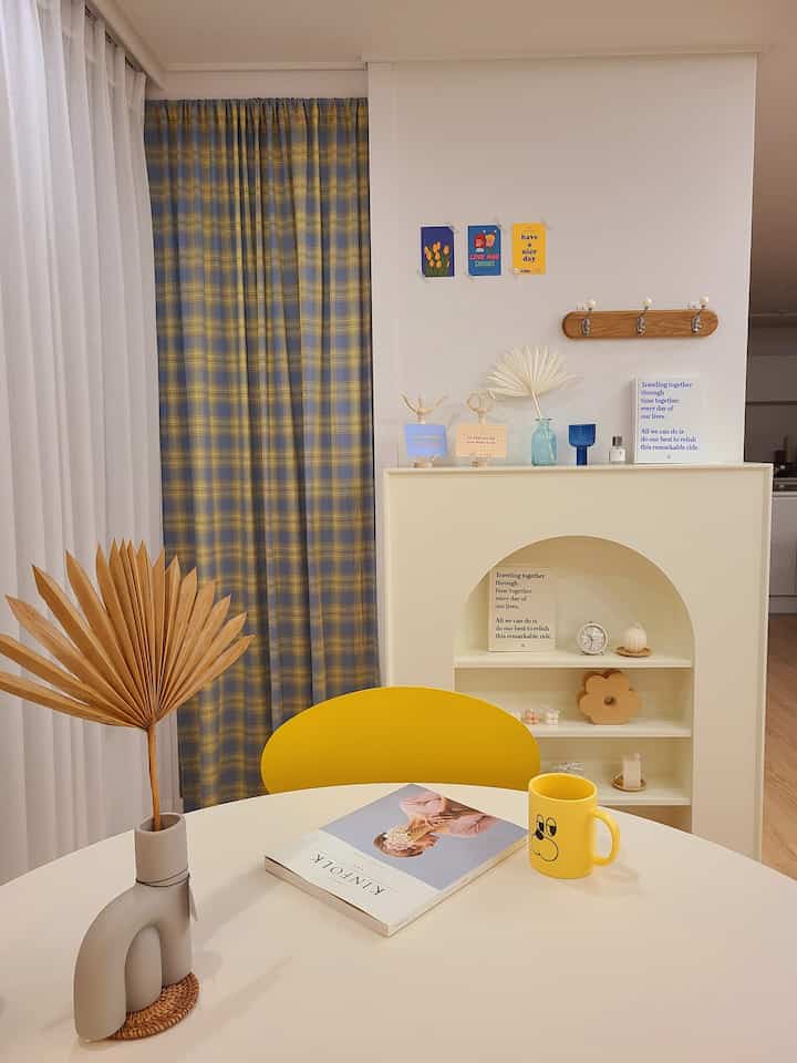 A home cafe space featuring yellow and blue checked curtains combined with simple white interior elements