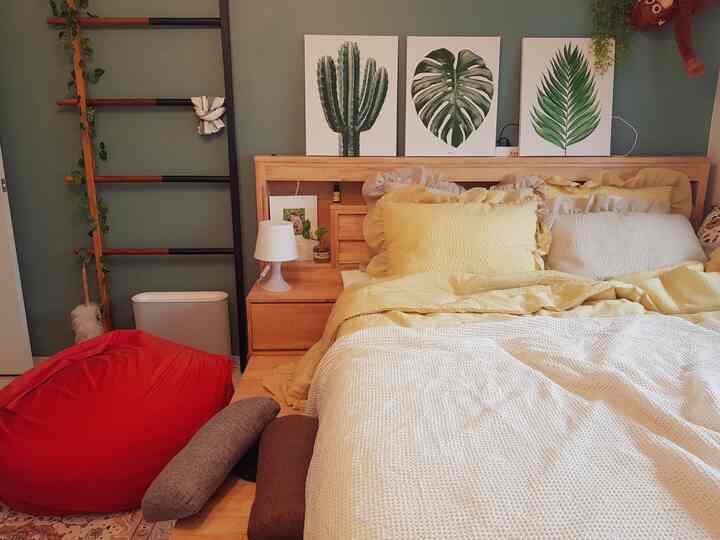 Wood tone and beige bedroom featuring natural wooden bed frame and yellow bedding in a simple, natural atmosphere