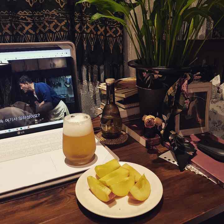 Brown wood tone desk in a studio apartment with beer and fruit plate for a drinking alone space
