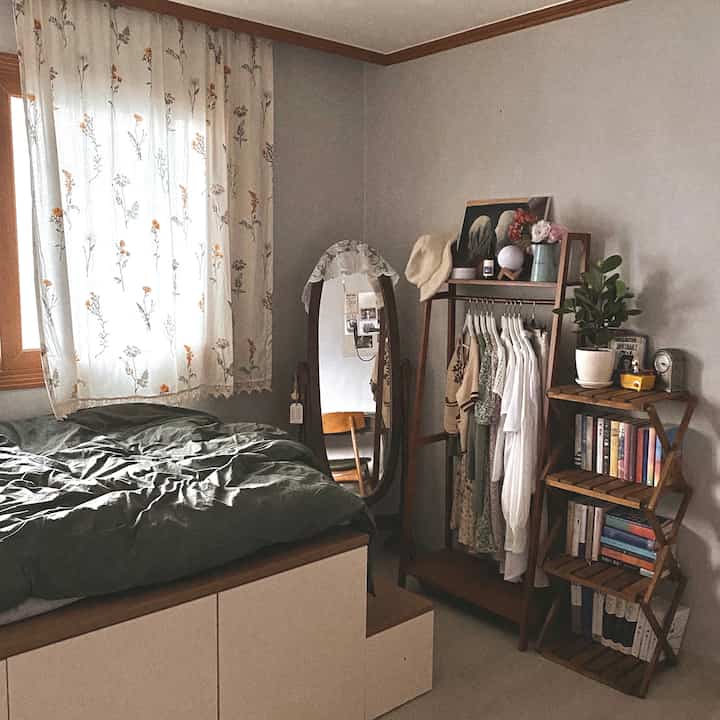 ナチュラルな木目調の寝室、花柄カーテンと木製家具が配置された雰囲気のある空間