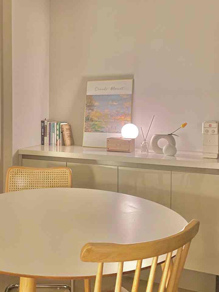 Natural wood tone and white kitchen home cafe space featuring a Monet poster and ambient lighting creating a cozy atmosphere