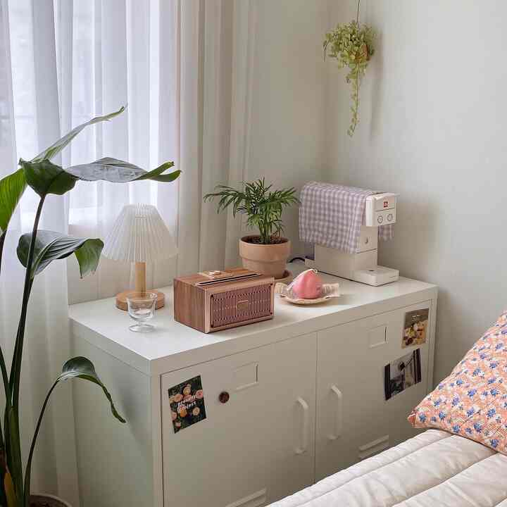 Bright natural white-toned bedroom featuring plants and coffee machine in a cozy home cafe setting