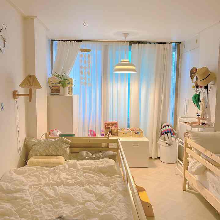 明るいナチュラルな木製ベッドと白いカーテンが配置された子供部屋、温かみのある雰囲気のあるインテリア