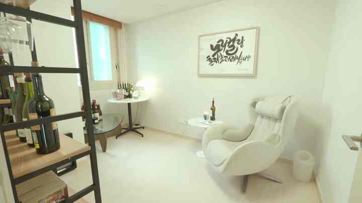 Bright white-toned home bar space featuring a wine rack and comfortable armchair with a cozy atmosphere