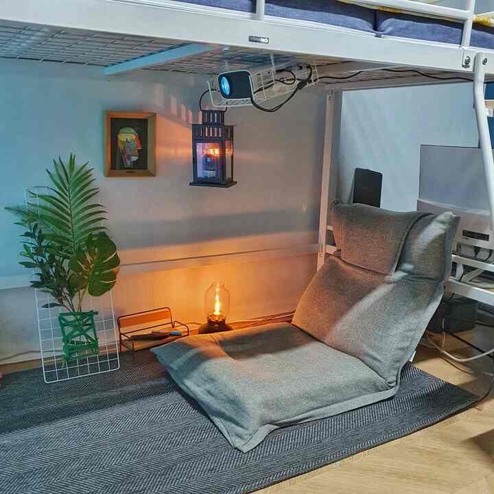 グレーの床椅子が配置されたナチュラルモダンな6畳の部屋、プロジェクターとラグがくつろげるホームシネマの雰囲気を演出