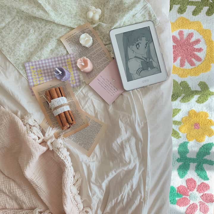 Natural Nordic style bedroom featuring white and beige bedding with candles and cinnamon sticks arranged delicately