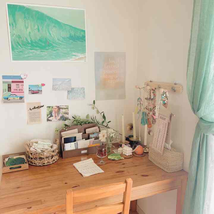 Natural small workspace in green and white tones, featuring a wooden table neatly organized with placemats and decorative objects