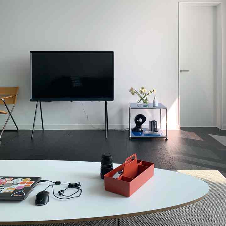 Black and white toned living room featuring Samsung Serif TV and a simple side table with modern and minimal atmosphere