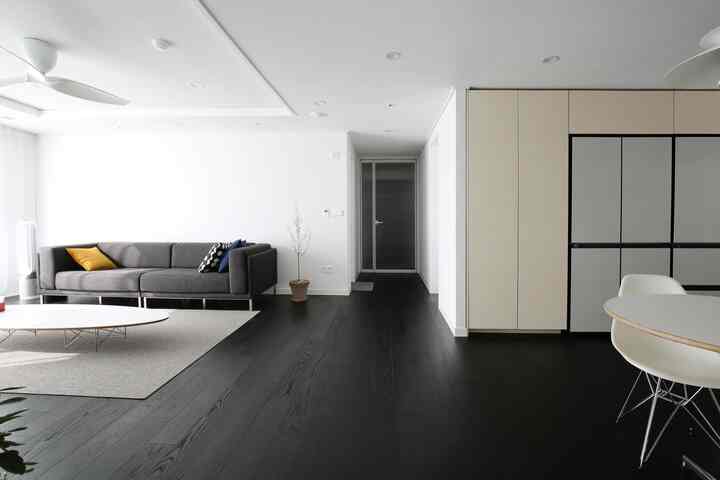 Modern living room in white and black tones, featuring a simple sofa and dining table in a clean space