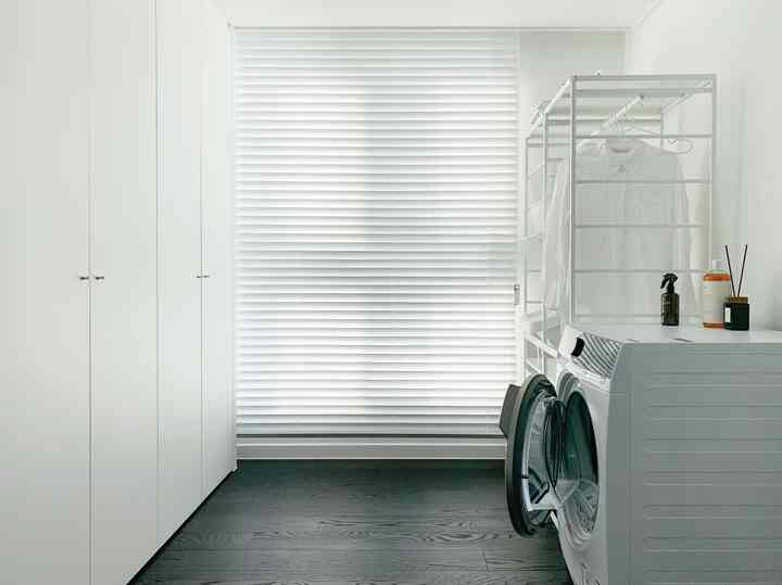 白を基調としたウォークインクローゼット、大型の白いクローゼットとエアドレッサー、ウィニックス乾燥機が配置された清潔感のあるモダンな空間