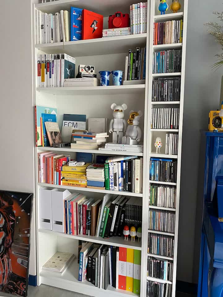 白を基調とした書斎、中央に配置されたイケアのBILLY本棚には本やフィギュアが整然と並べられた雰囲気のあるインテリア