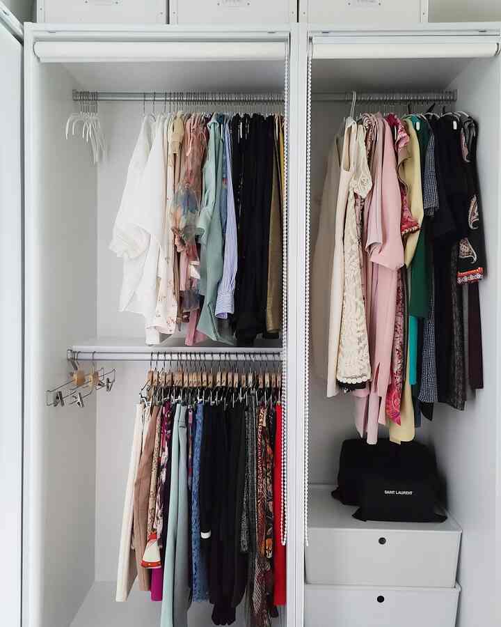 白を基調とした清潔感のあるウォークインクローゼット、ハンガーとチェストが配置された整理されたインテリア