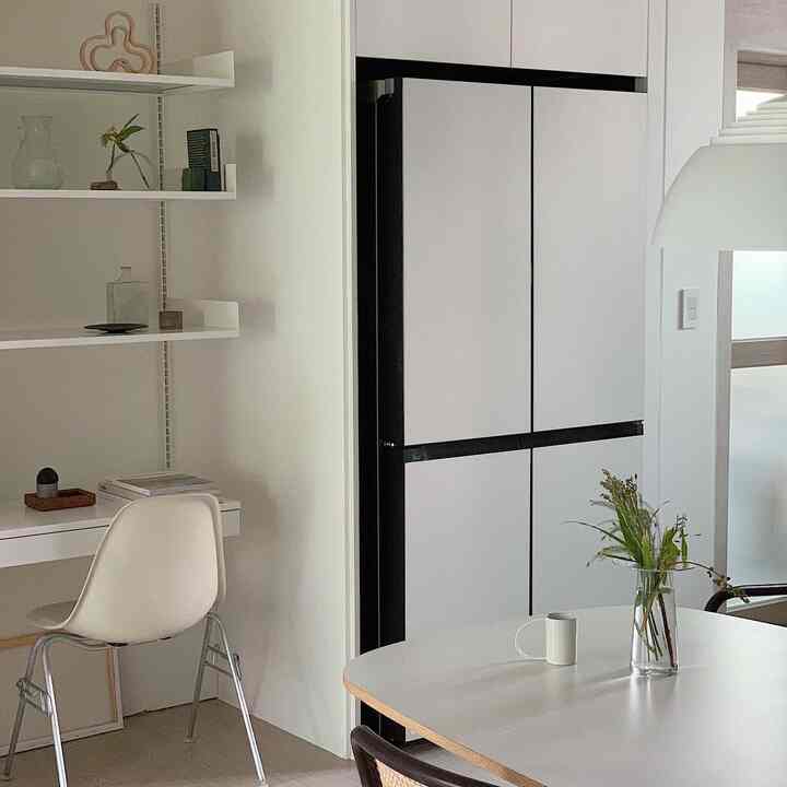 白色調のキッチンとダイニング空間、シンプルな家具とペンダントライトが調和した清潔感のあるインテリア