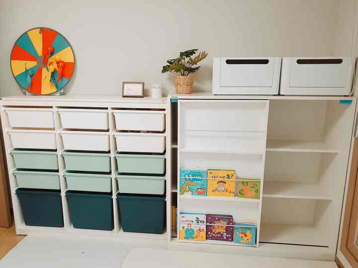 白を基調とした子供部屋、複数の収納棚とおもちゃ収納が整った雰囲気のあるインテリア