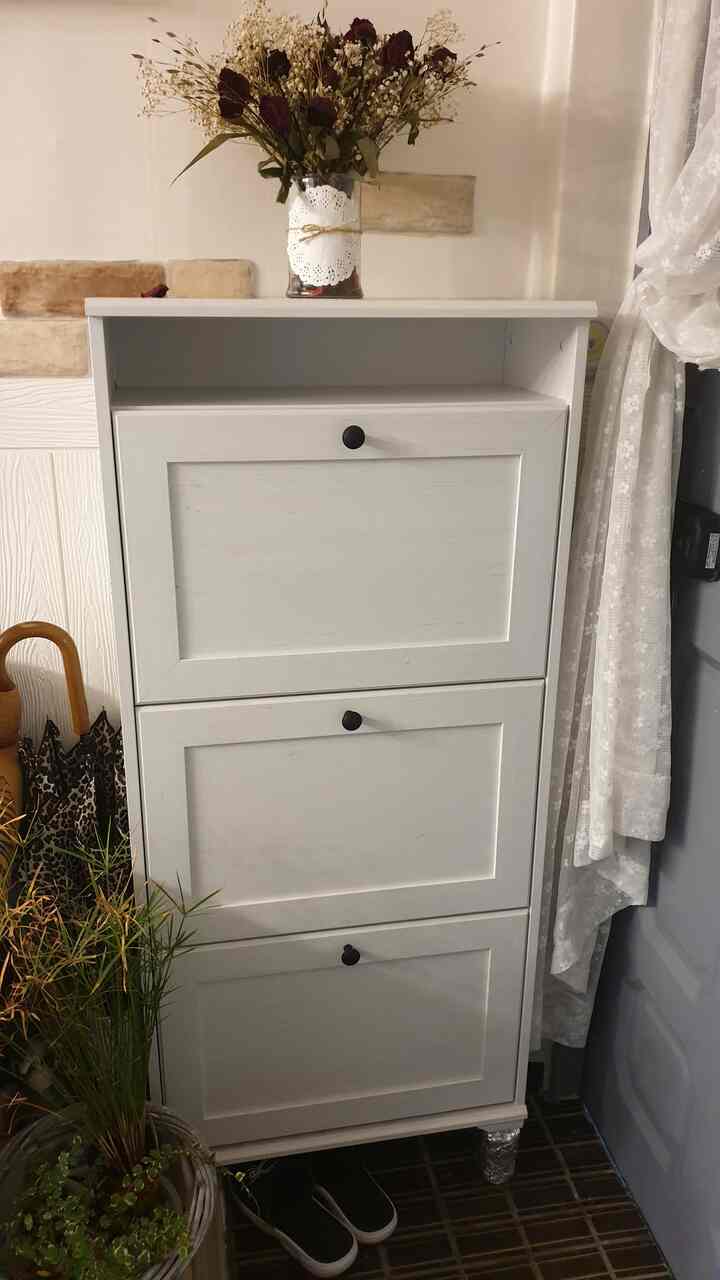 白色調の玄関、モダンなシューズラックが中央に配置されたすっきりとした空間