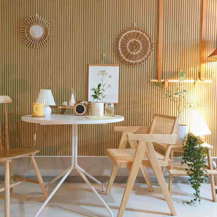 ナチュラルな木目調と白を基調としたリビング、白い円形テーブルとラタンチェアが配置された雰囲気のあるおうちカフェ空間